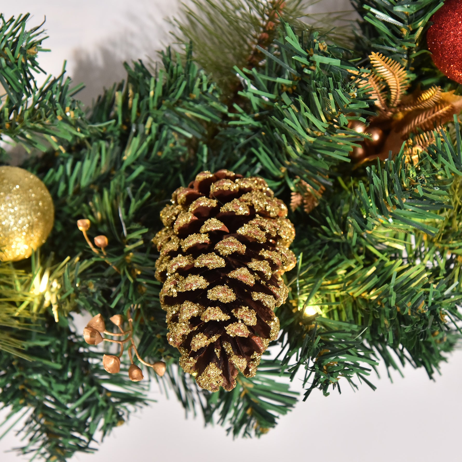 Couronne de Noël artificielle lumineuse avec 20 LED de 60 cm - décorée de houx et de pommes de pin